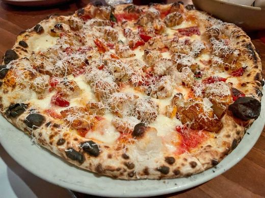 A wood-fired pie topped with fennel sausage, roasted red peppers and a snowfall of grated pecorino, the crust blistered black in spots
