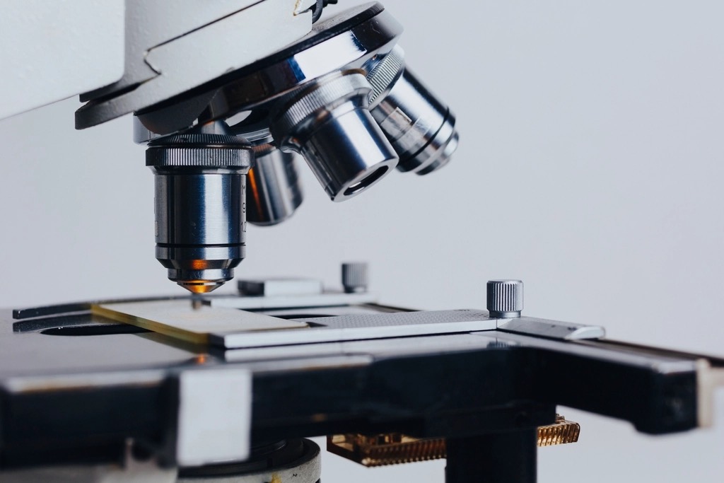 Close view of a laboratory microscope with its objective lenses above the stage